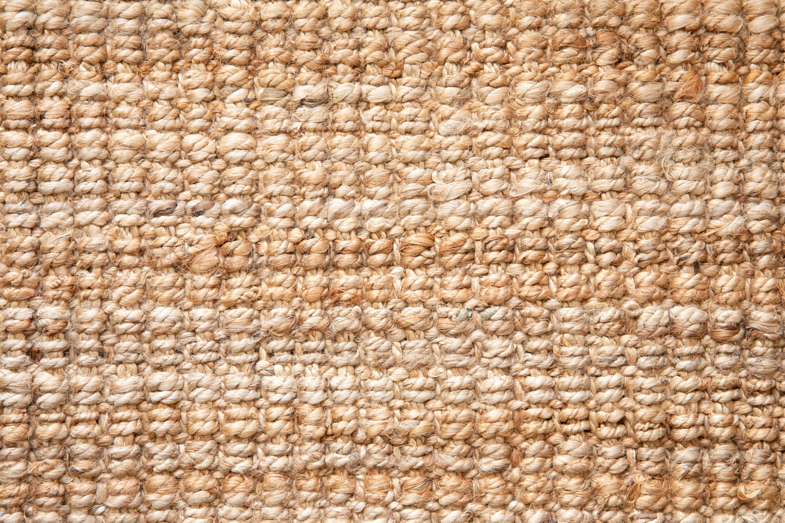 Flat lay view of natural color braided jute material doormat. Background texture concept.